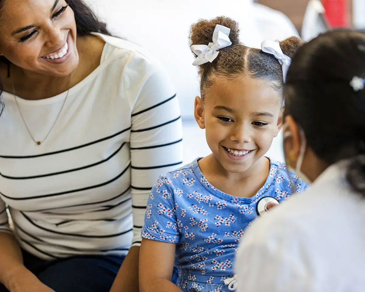 Young girl smiling and talking to a doctor