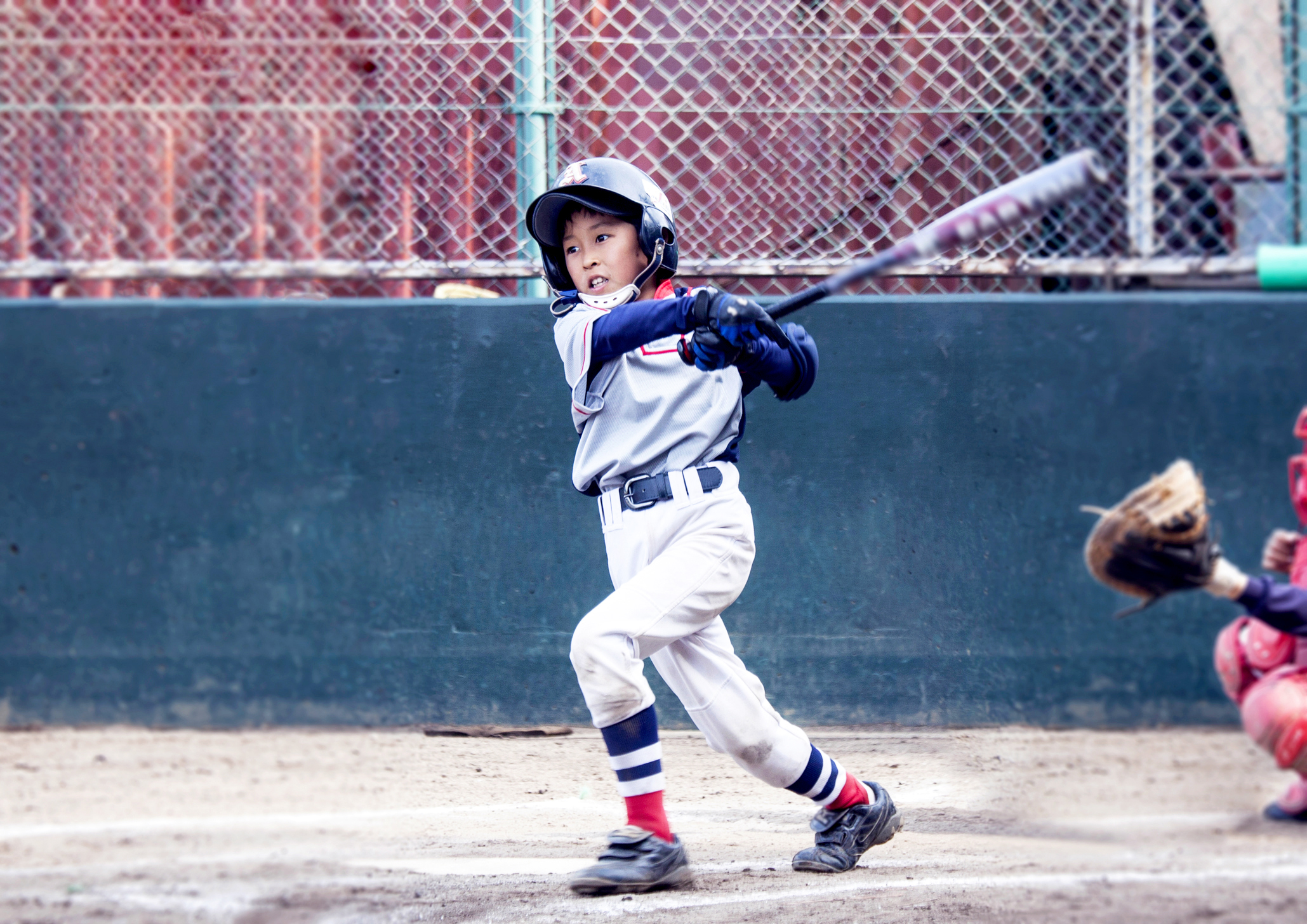youth baseball player swinging bat